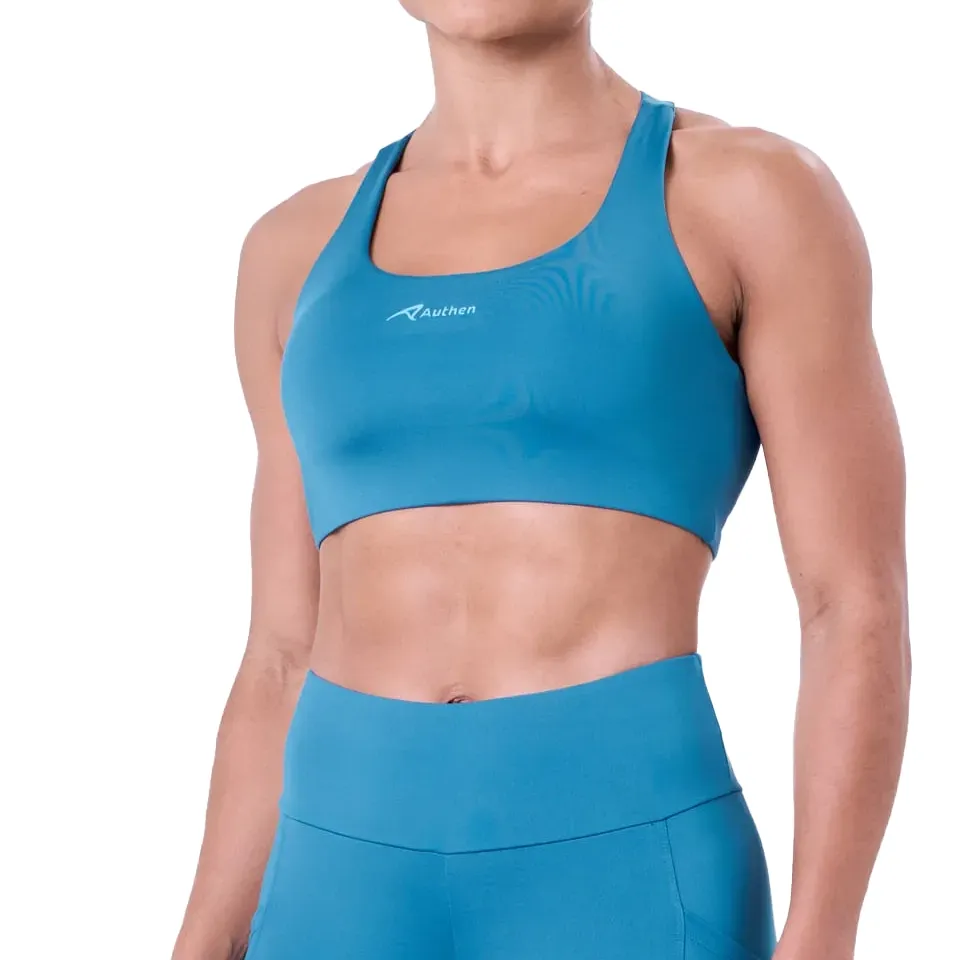 Mulher usando top esportivo azul nadador Authen, vista frontal com logo da marca no peito